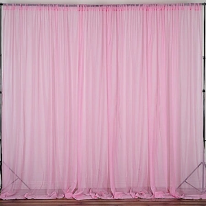 Pink sheer voile backdrop with a black metal frame on a wooden floor.