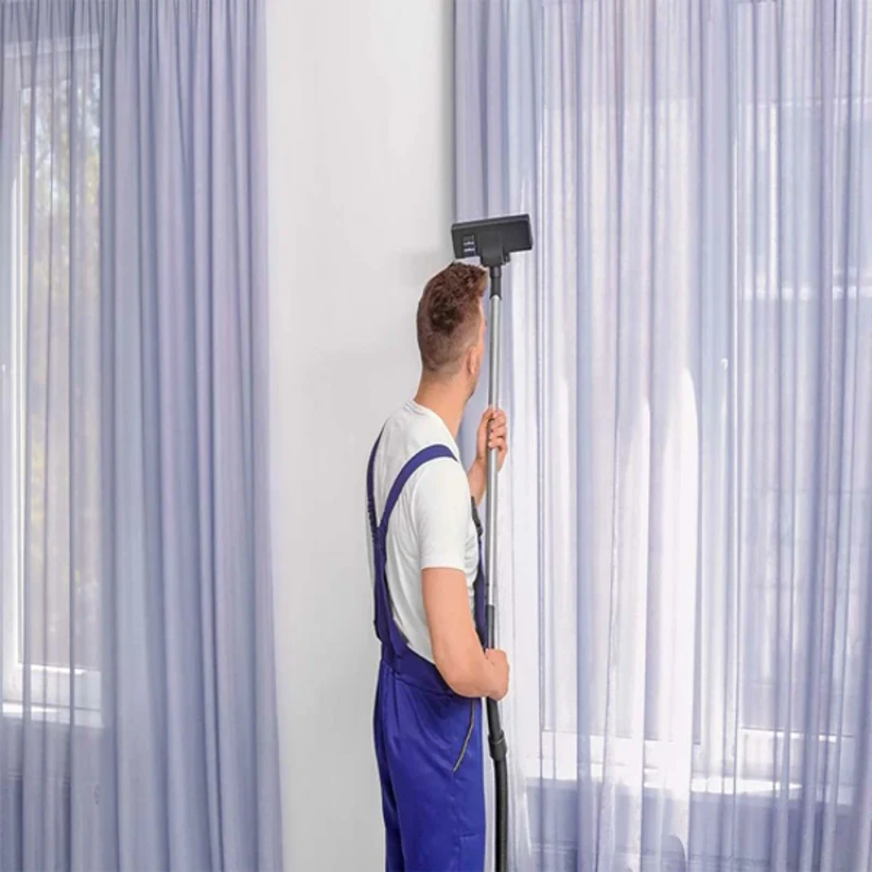 Professional cleaner vacuuming blackout curtains in Dubai for dust removal and maintenance